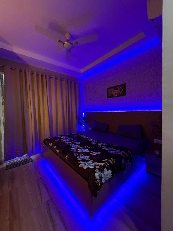 a bedroom with a bed with blue lights at Happy Stay expo in in Greater Noida
