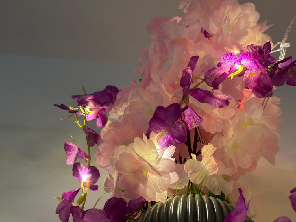 a vase filled with purple and white flowers at Swarga Fireflies Duo in Bengaluru