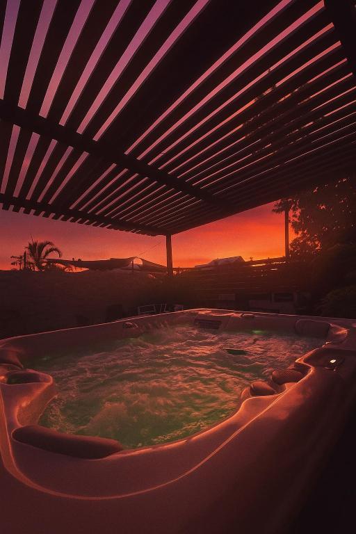 a hot tub with a sunset in the background at Eau clair de lune - Vincendo in Saint-Joseph