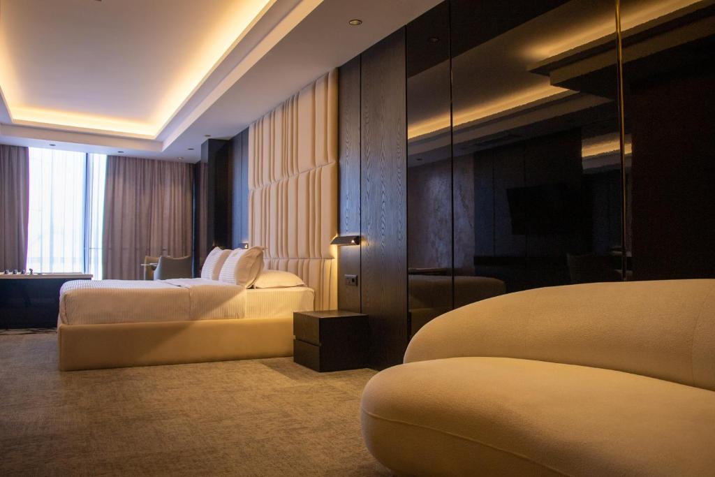 a hotel room with two beds and a mirror at Hotel Chicago in Shkodër