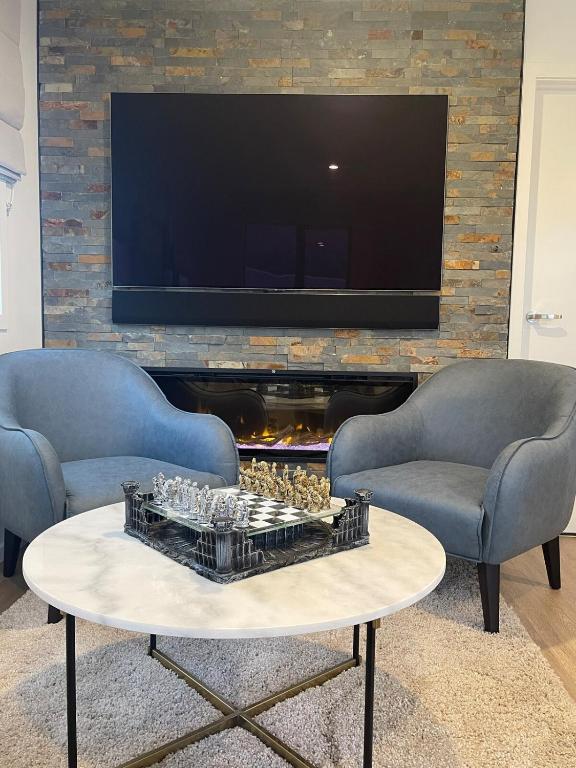 a living room with two chairs and a coffee table at Spa apartment in Queenstown in Queenstown Airport