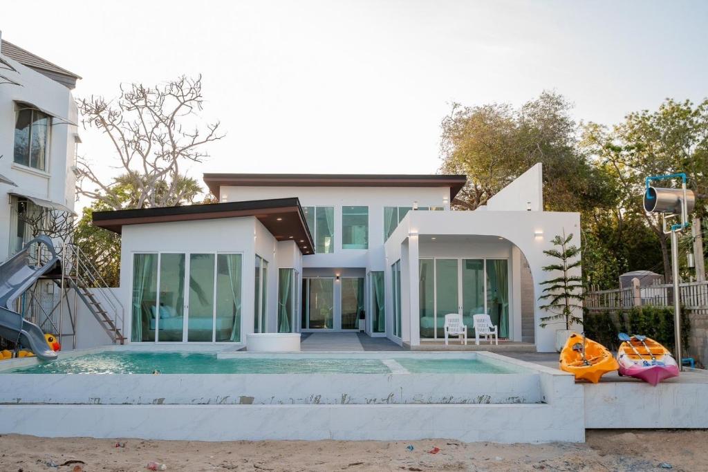 a home with a swimming pool and a house at Sea Sand Sun Pool Villa cha-am in Cha Am