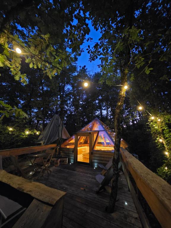 a lit up tent in the woods at night at La Cachette - Gîte & Hébergements Insolites - Spa in Rivière-sur-Tarn