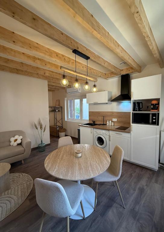 a kitchen with a table and chairs in a room at La Petite Couze, Maison cozy pour 2 en Auvergne in Le Breuil-sur-Couze