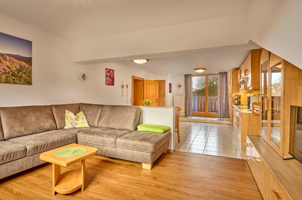 ein Wohnzimmer mit Sofa und Tisch in der Unterkunft Pension Zum Rechen in Bodenmais