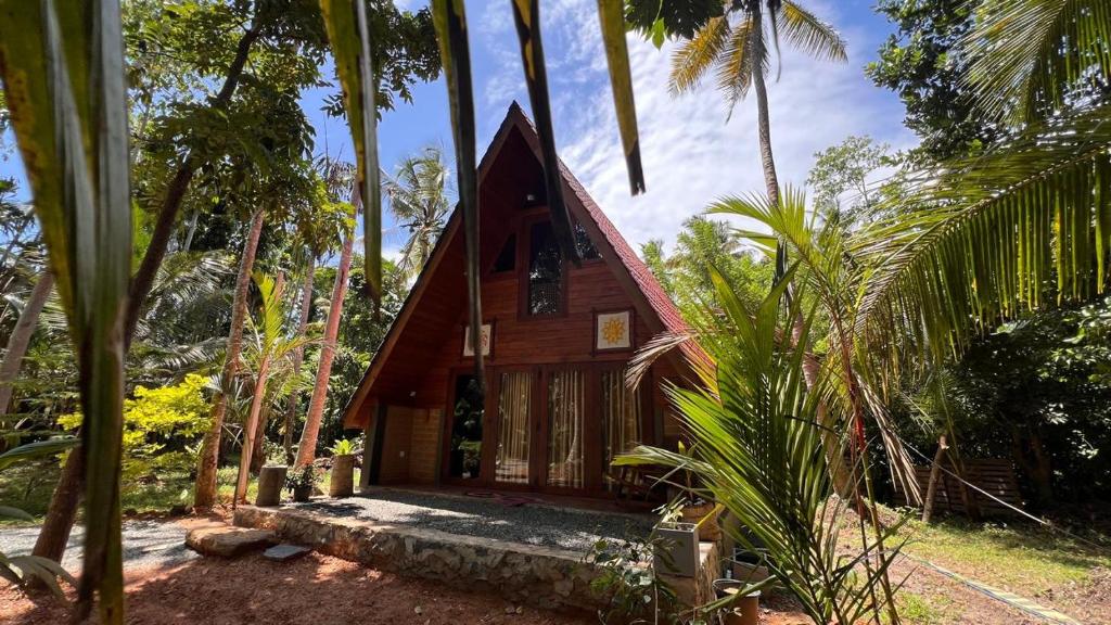 a small wooden house in the middle of palm trees at Siri Villa Cabana Habaraduwa in Habaraduwa