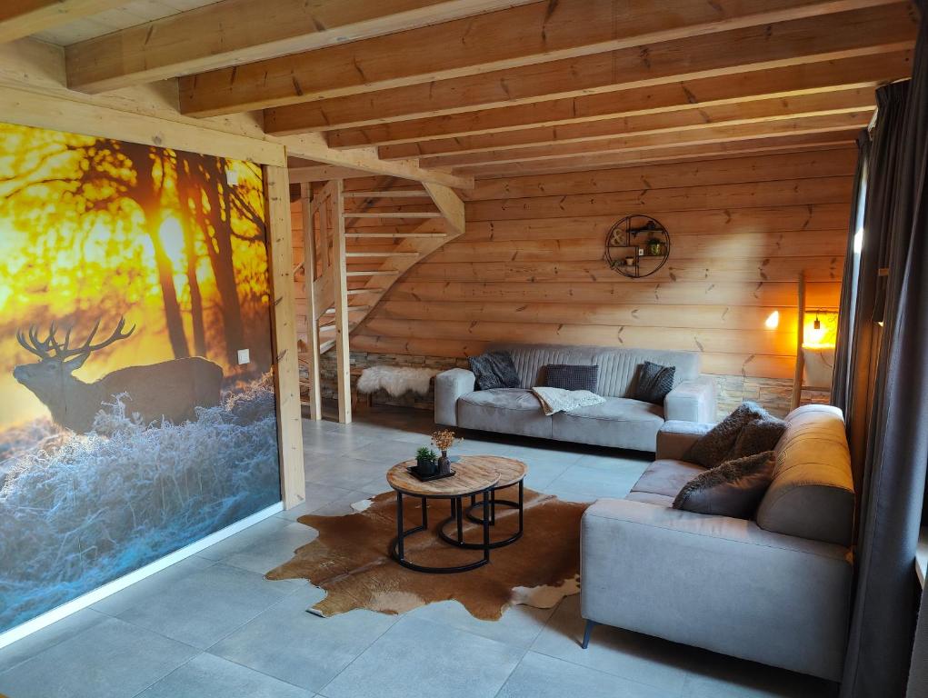 a living room with a large painting of a deer at Chalet Momage dichtbij Skiliften, Skiverhuur en Bikepark! in Winterberg