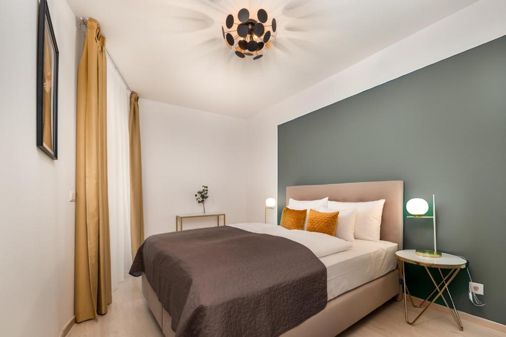a bedroom with a large bed and a chandelier at Vagabond Grand'Or in Budapest