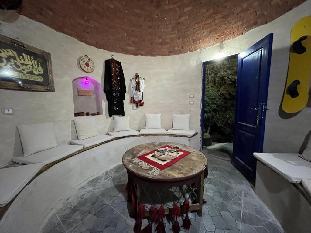 a room with white chairs and a table and a blue door at Bait Gamal Siwa بيت جمال سيوة in Siwa