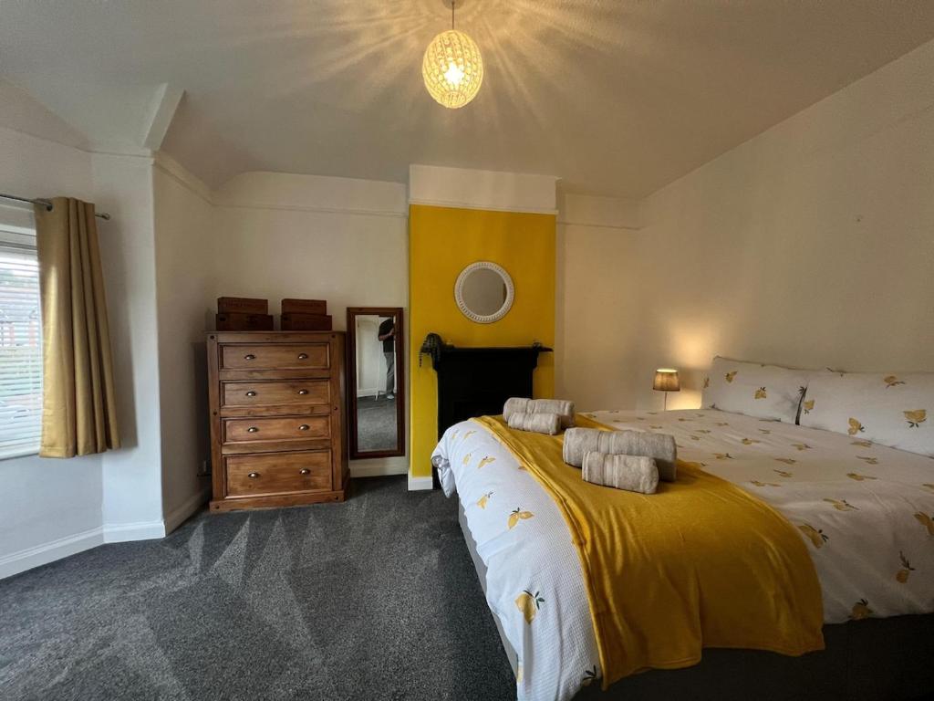 a bedroom with a large bed and a dresser at Beach Hill House - Rhos on Sea in Colwyn Bay