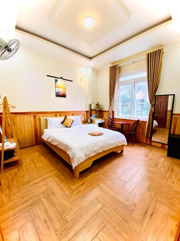 a bedroom with a bed and a wooden floor at Khách Sạn Bình Nguyên Đà Lạt in Da Lat