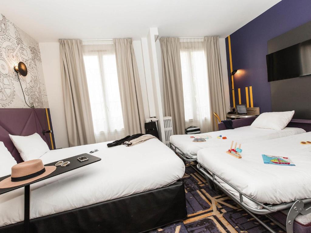 a hotel room with three beds with a hat on them at ibis Styles Paris Mairie De Clichy in Clichy