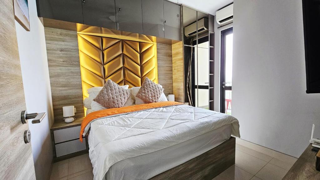 a bedroom with a bed with a yellow headboard at Cozy Apartment with Sea View - One Residence in Pulau Sembakau Kecil