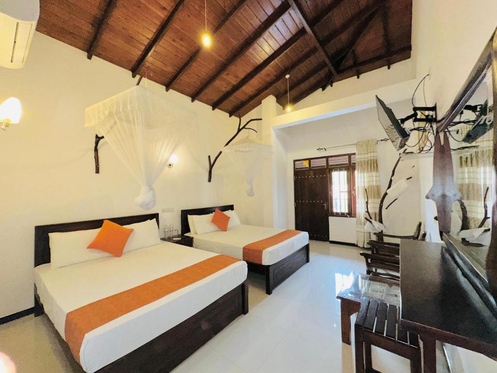 Giường trong phòng chung tại Elephant Orphanage Edge Hotel