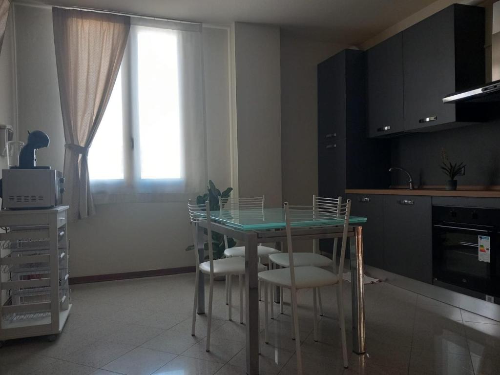 a kitchen with a table with chairs and a window at La Casa di Leo in Stabbia