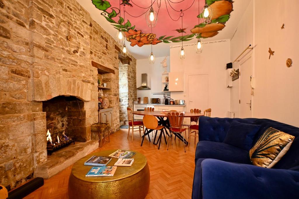 ヴァンヌにあるAppartement Centre Historique Cheminée, Mur en Pierre & Déco Jungleのソファと暖炉のあるリビングルーム