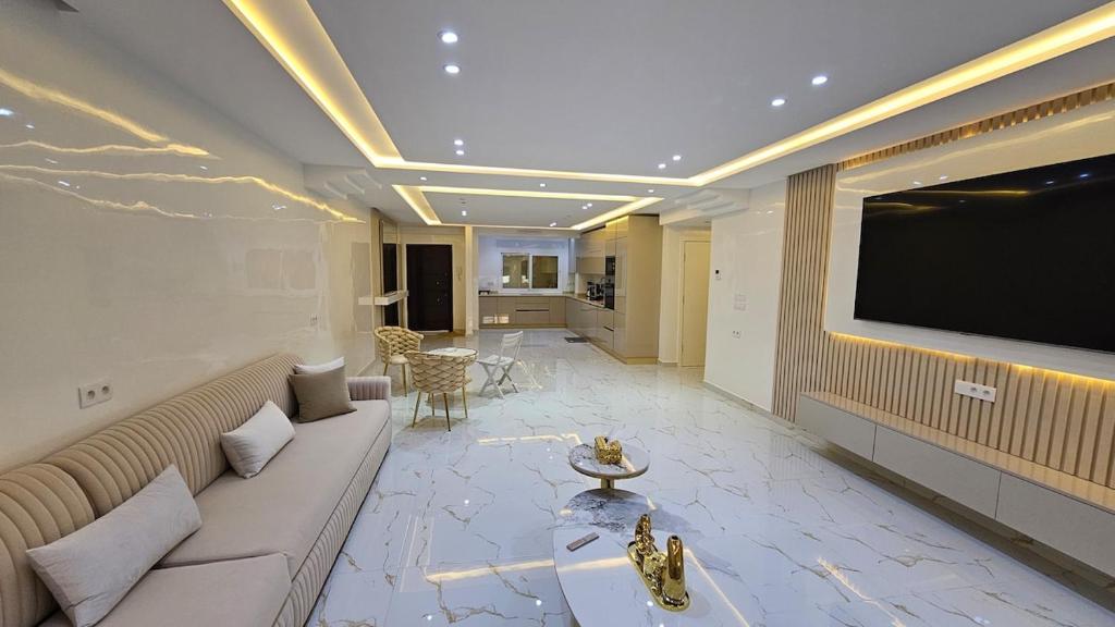 a living room with a couch and a flat screen tv at Tanger Luxury 4BR with AC WiFi and Beach Access in Tangier