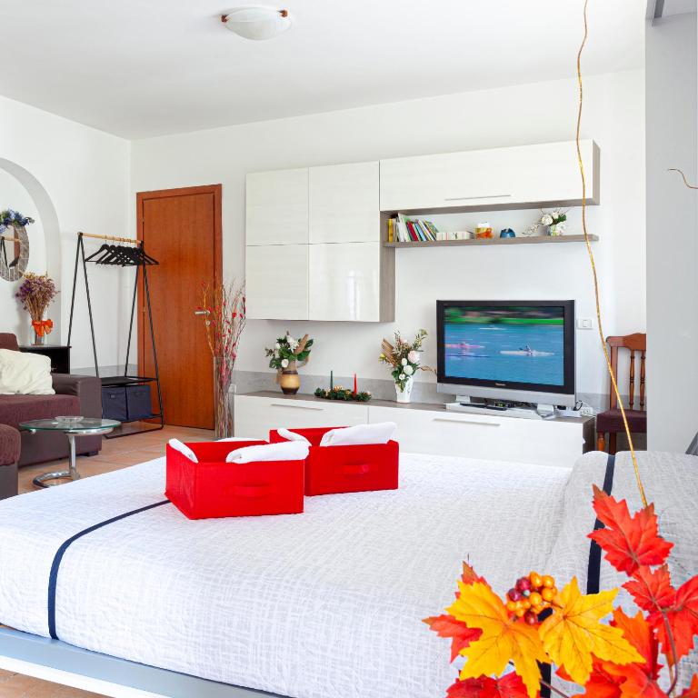 a white bedroom with a large white bed with red pillows at Open Space Valnerina in Piedipaterno