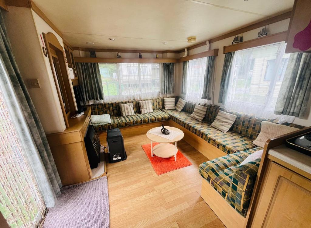 a living room with a couch and a table at Caravane en pleine nature ferme proche de tout in Philippeville