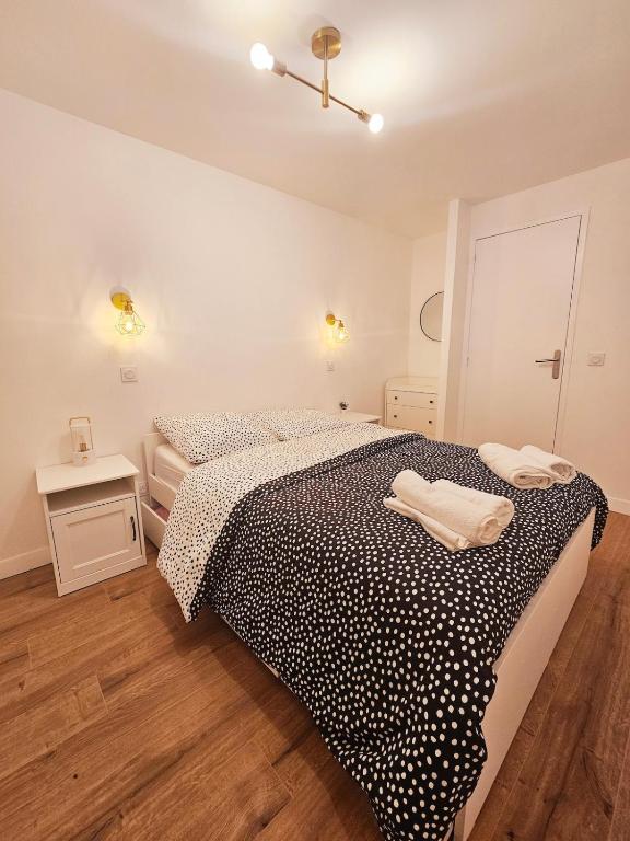 une chambre avec un lit avec une couette noire et blanche dans l'établissement Chez Maria, à Lourdes