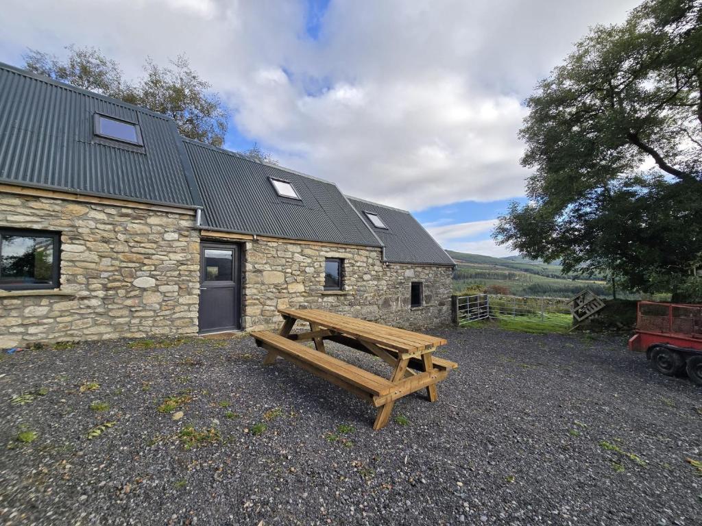 a wooden bench in front of a stone building at Aghavannagh Mountain Lodge in Aghavannagh