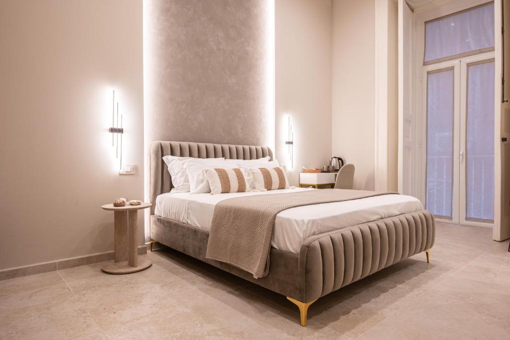 ナポリにあるMadame Toledo Luxury Roomsの大きなベッドと大きな窓のある寝室
