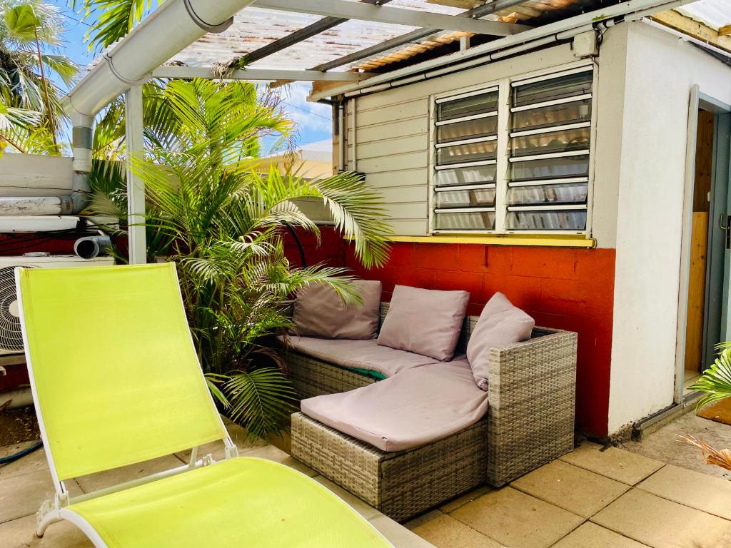a chair and a couch on a patio at Saline les bains studio avec cuisine & espace détente extérieurs calme & plage à pied in Saint-Paul