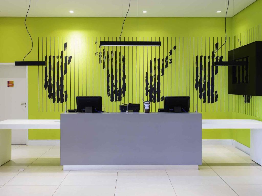 Una habitación con un mostrador blanco y una pared verde. en ibis Styles Ponta Pora, en Ponta Porã