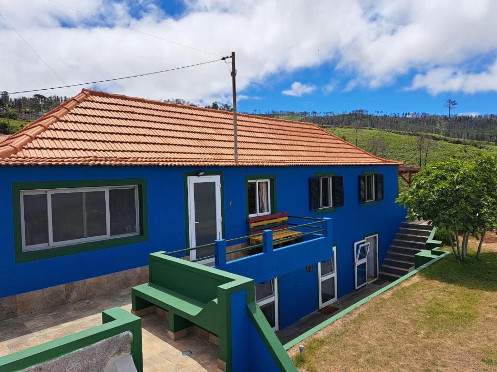 una casa azul con un banco verde delante de ella en This Old House, en Lombada Velha
