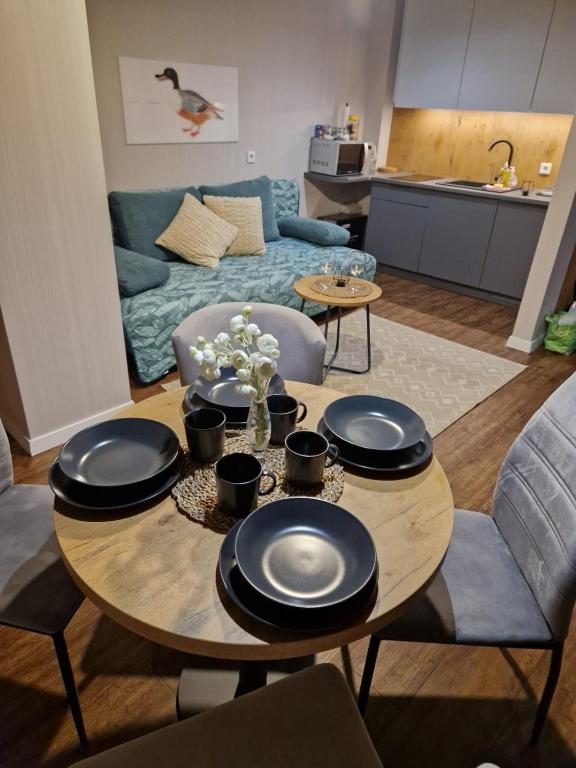 a living room with a table and a couch at Kozubnik Apartment in Porąbka