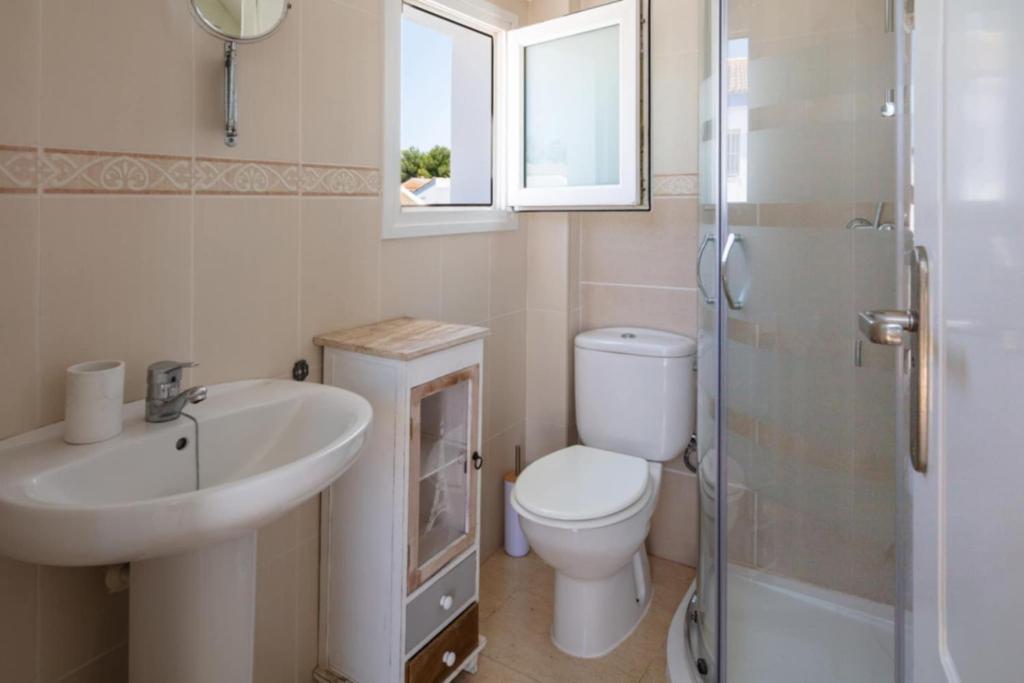 Un baño con inodoro, lavabo y ducha. en The Beach house, en El Verger