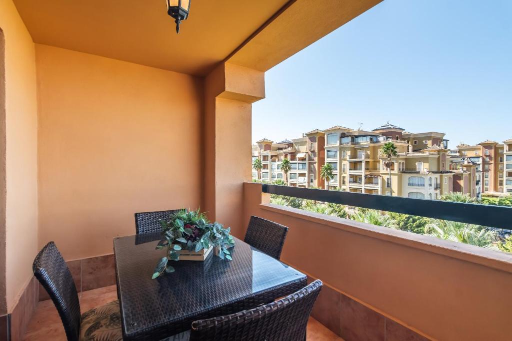 een balkon met een tafel en stoelen en uitzicht op de gebouwen bij Los Albatros by Ĥ - Playa de los Haraganes HAHB30P190 in Isla Canela