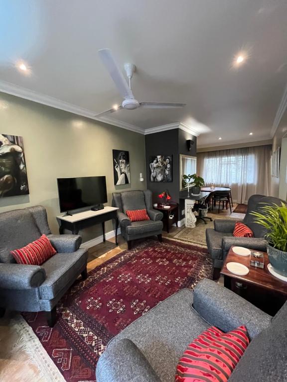 a living room with couches and a flat screen tv at Somerset West Garden Apartments 4 in Somerset West