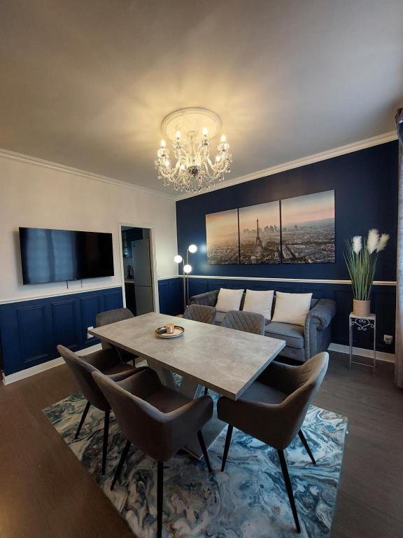 ein Wohnzimmer mit Tisch und Couch in der Unterkunft Villa Napoleon in Les Lilas