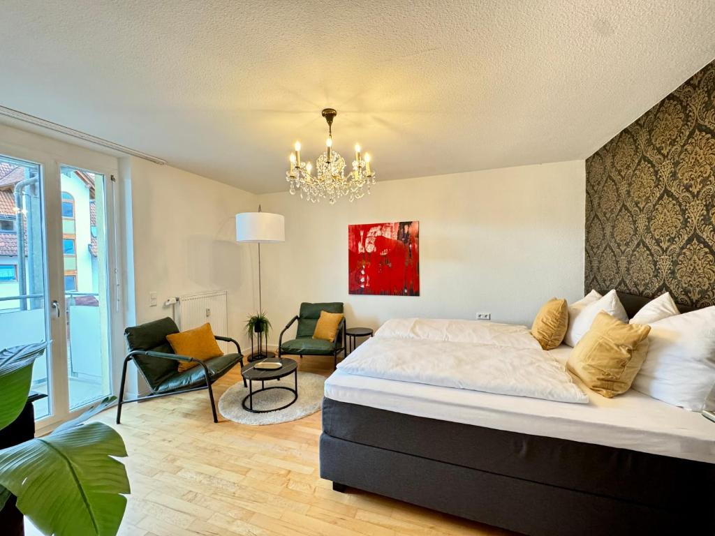 a bedroom with a large bed and a chandelier at Renaissance Boutique Apartment - Bad Krozingen in Bad Krozingen