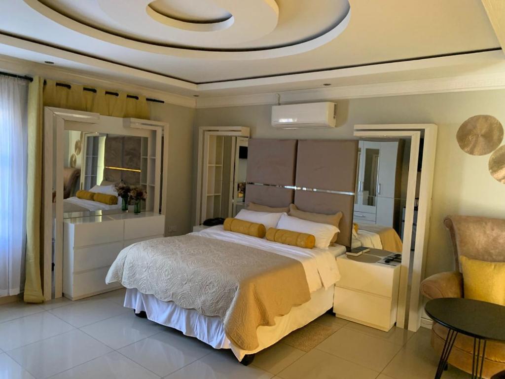 a bedroom with a large bed and a large mirror at Cozy Star Guesthouse Pty Ltd in Mmaraka