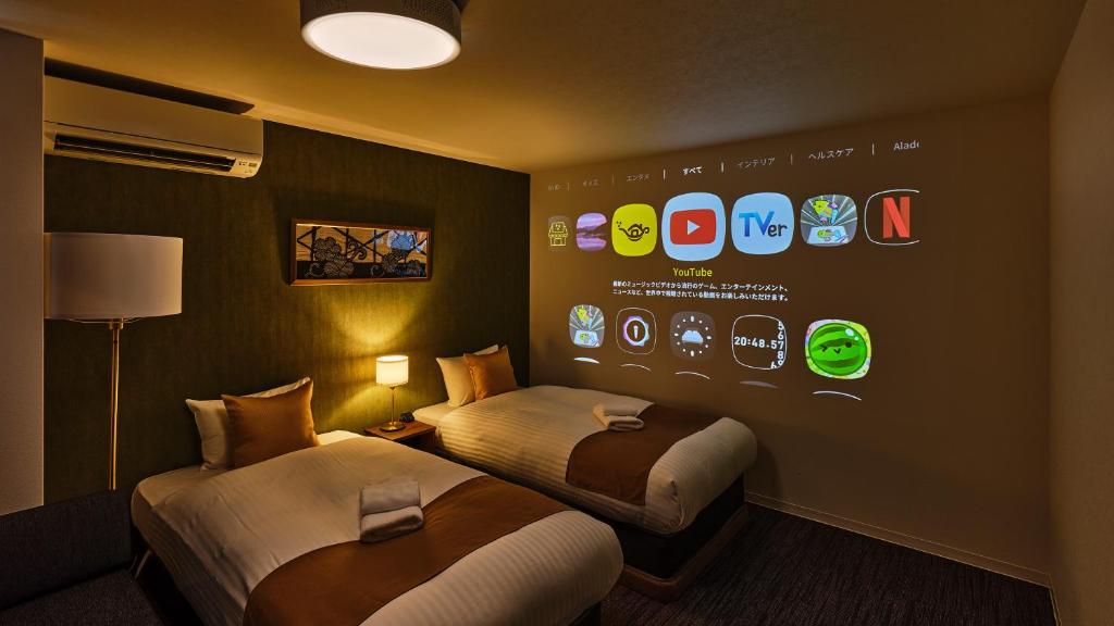 a hotel room with two beds and a display of apps at &zen Kyoto Gion in Kyoto