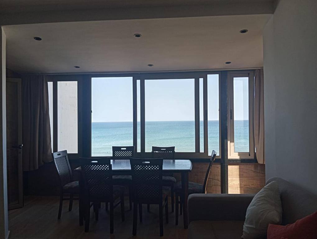 a dining room with a table and chairs and the ocean at Casa de Marinero in Martil
