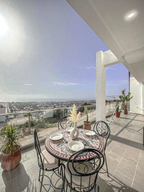 a table and chairs on a balcony with a view at Appartement Luxe OMiramar Balcon Privé Vue in Agadir