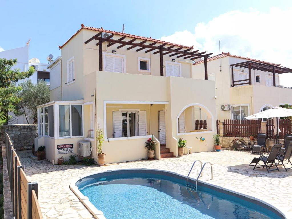 a villa with a swimming pool in front of a house at Naya Home - New listing! in Almirida