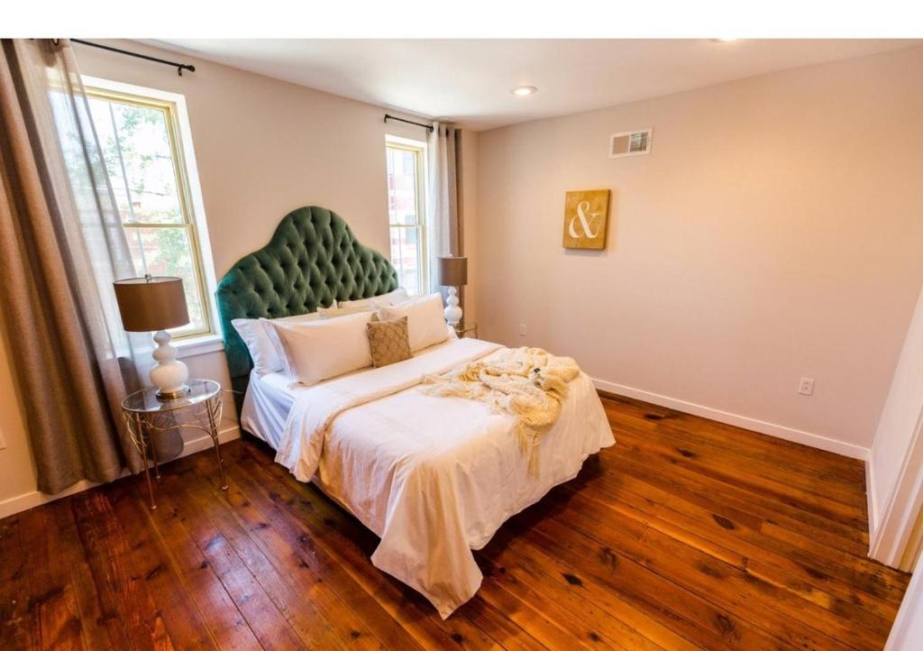 a bedroom with a large bed with a green headboard at Artsy Hidden Gem --- FREE PARKING in Philadelphia