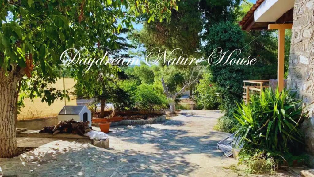 a picture of a yard with a tree and a house at Daydream Nature Home - Hot Tub & Cinema Experience in Oinóï