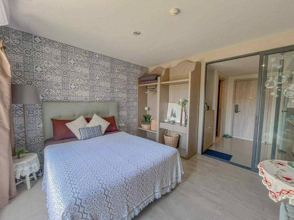 a bedroom with a bed with a blue and white bedspread at Exclusive Apartment with Pool - Self Check In in Hua Hin
