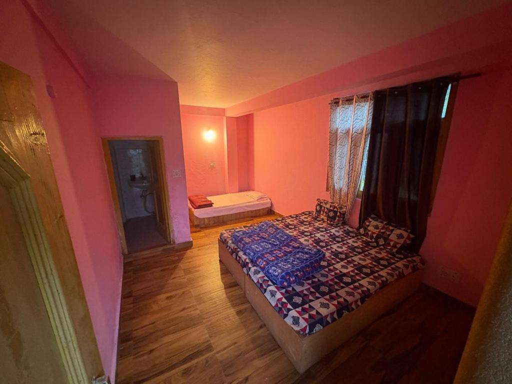 a bedroom with pink walls and a bed in it at Chai and chimneys in Manāli
