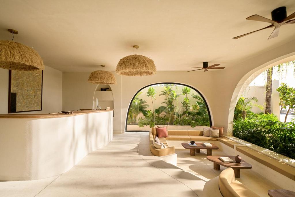 A sunlit lounge with arched windows, built-in seating, and a reception counter.