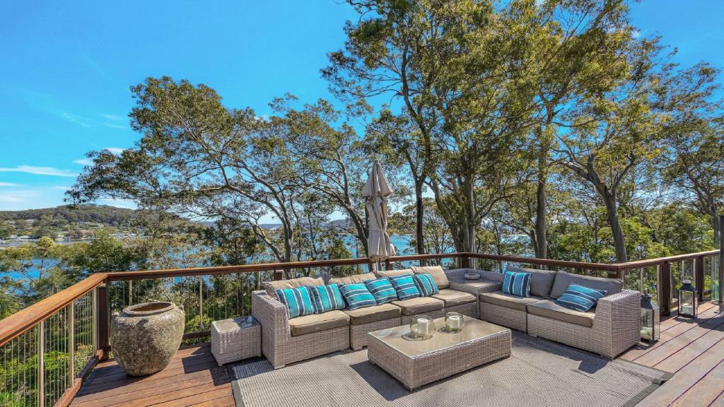 a patio with a couch and a table on a deck at 'Hampton Cottage' by HolidayCo in Pretty Beach