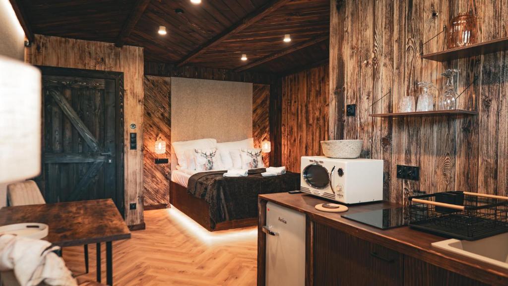 a bedroom with a bed and a desk with a microwave at Highland Apartments Pod Gubałówką in Zakopane