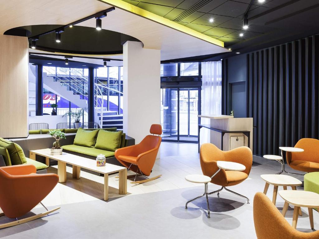 a living room with chairs and a couch and tables at Novotel Tours Centre Gare in Tours
