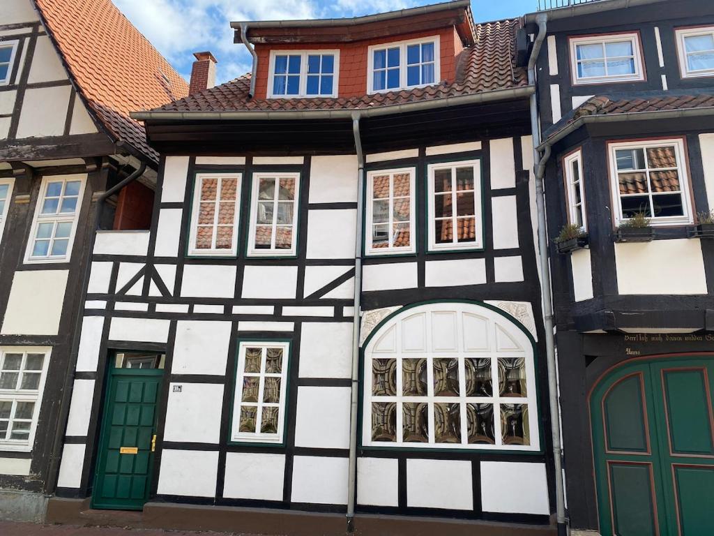 a black and white building with green doors at Maison à Colombage - Heimkino & Altstadt-Flair in Hameln