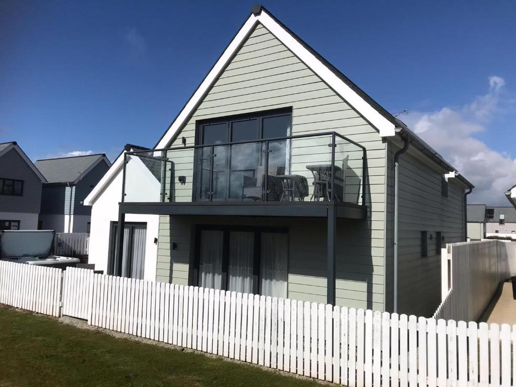a house with a white fence in front of it at Black Sea Horse in Westward Ho